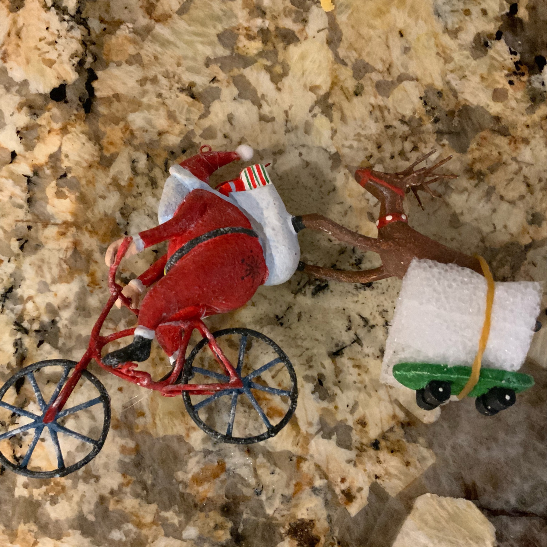 Ornament with Santa pulling Rudolph on a skateboard which had broken off
