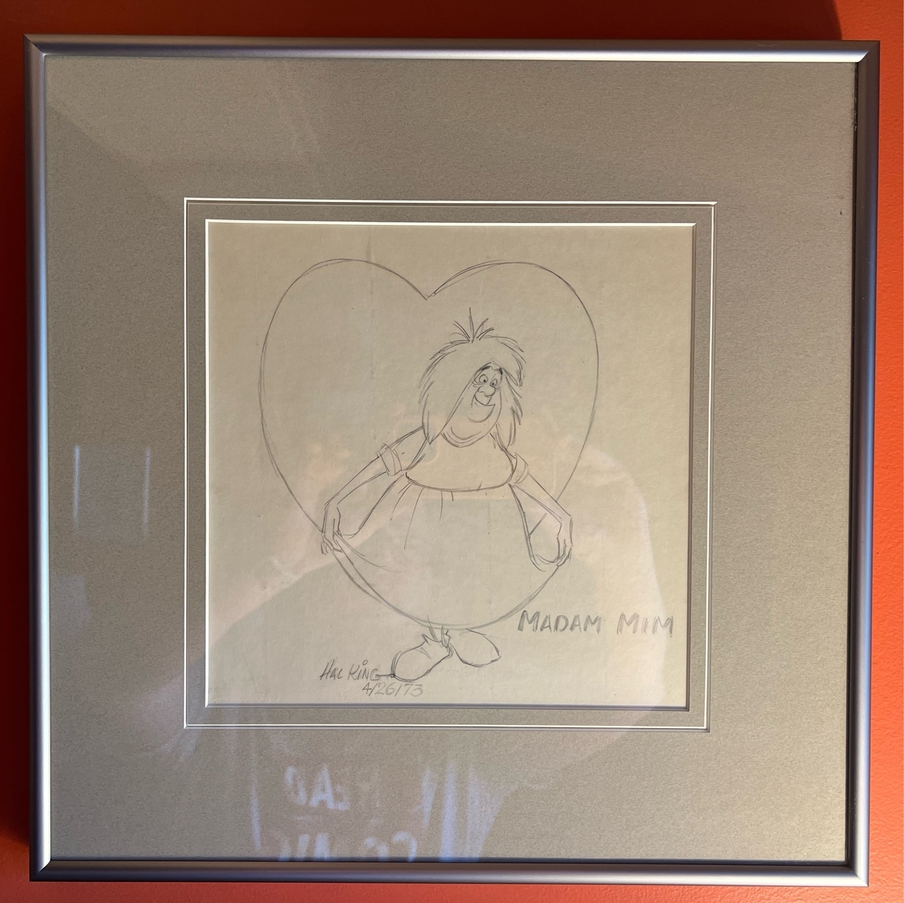 Sketch of Madam Mim beginning a curtsey, with a large heart background. Captioned "Madam Mim" in capital letters, and Hal King's signature. 