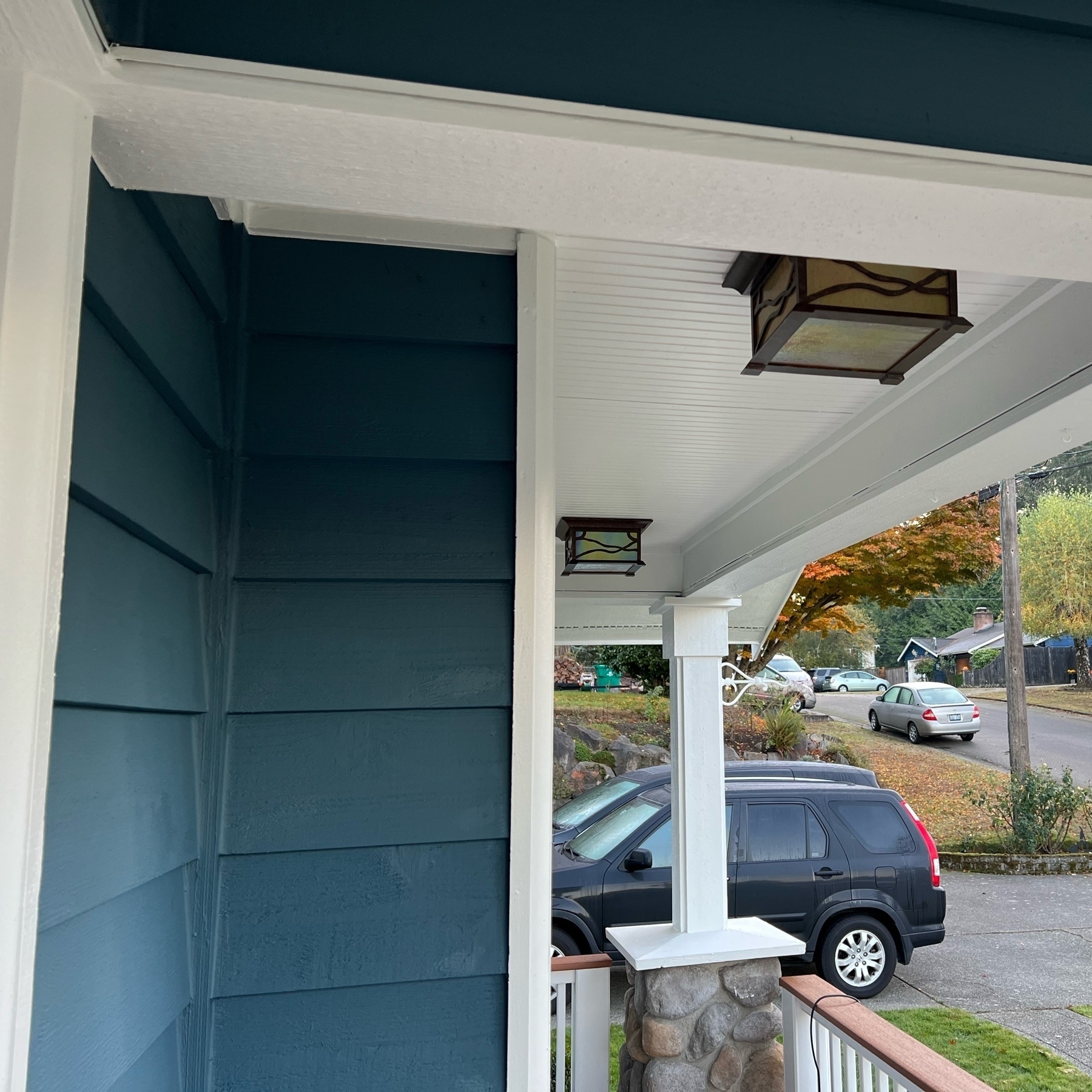 Side view of the small front porch, with two square arts and crafts styles lights overhead.